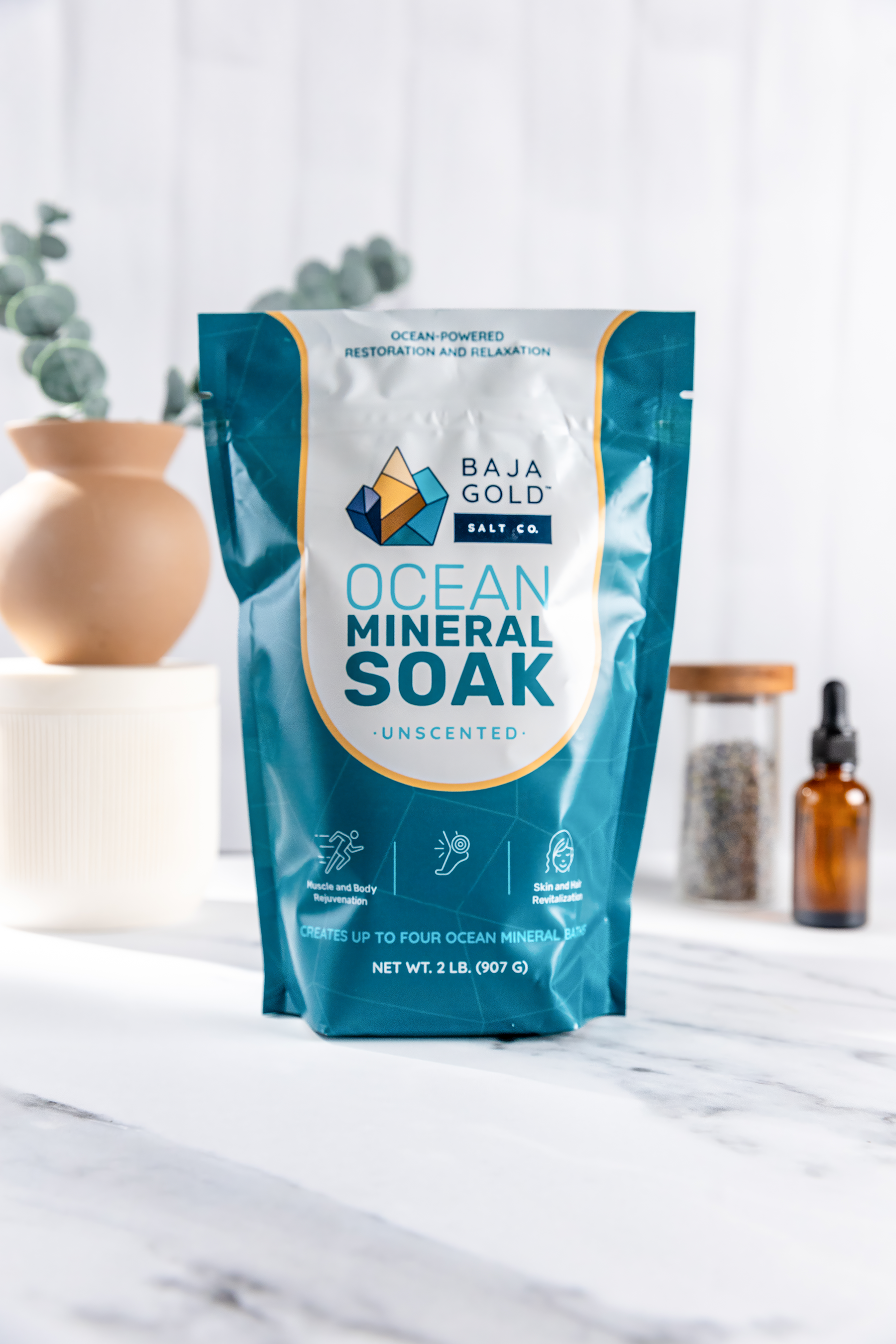 Baja Gold ocean mineral soak unscented package on a marble surface with decorative items in the background.